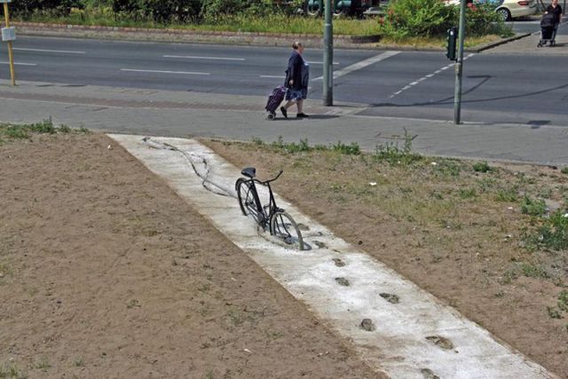 Attention béton frais! Visiblement un cycliste n'a pas bien compris l'avertissement. Est-il coincé dans le ciment quelques mètres plus loin?